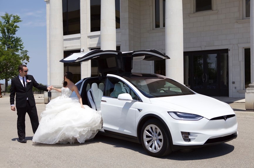 Couple getting out of a Tesla